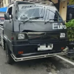 Pikap hitam dengan kaca depan retak dan kap penyok terparkir di halaman polres